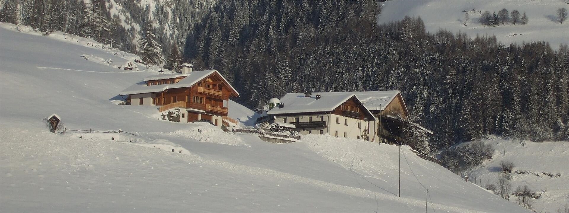 Pichlerhof und Holzhaus in verschneiter Winterlandschaft